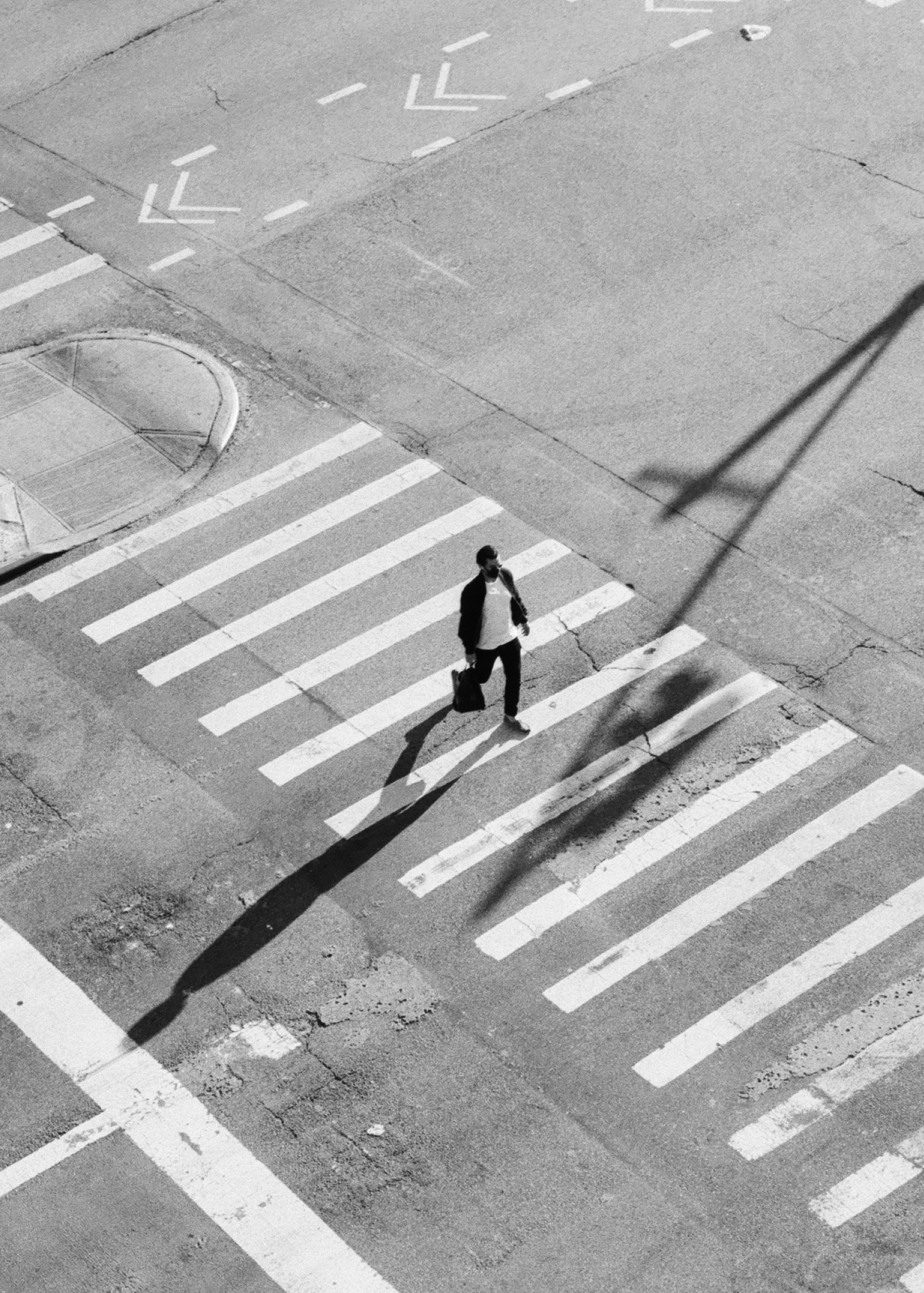 Pedestrian on zebra crossing shot on ILFORD HP5 plus black and white film by Louis Kassam