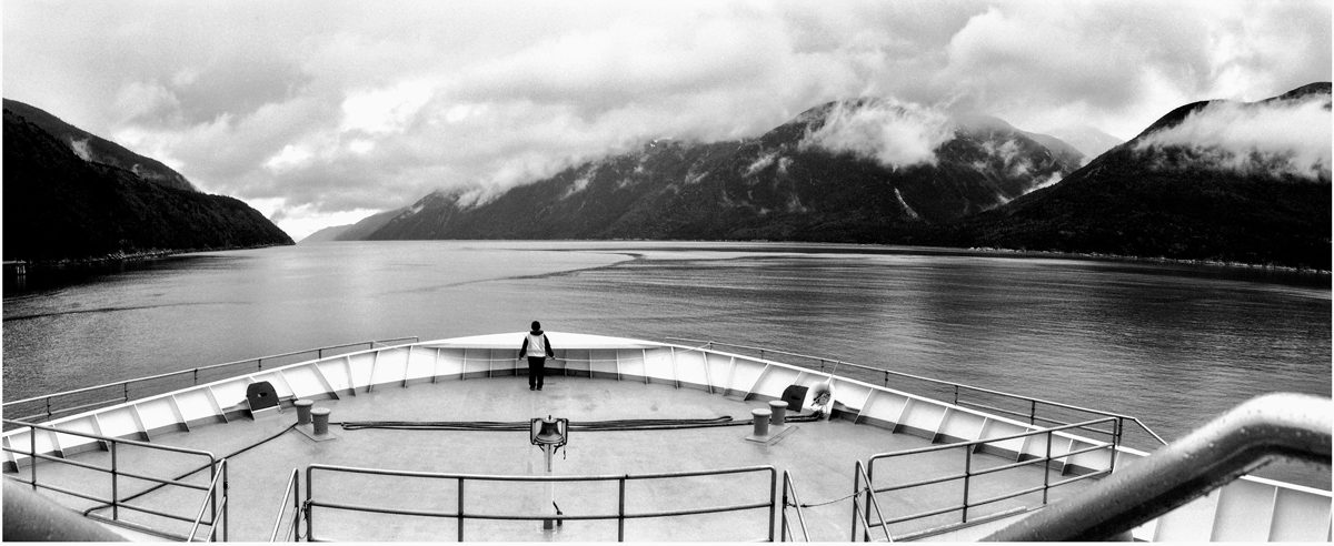 Friday Favourites #lycricallyspeaking. Black and white panoramic landscape image on a boat looking out to see with dramatic mountains.