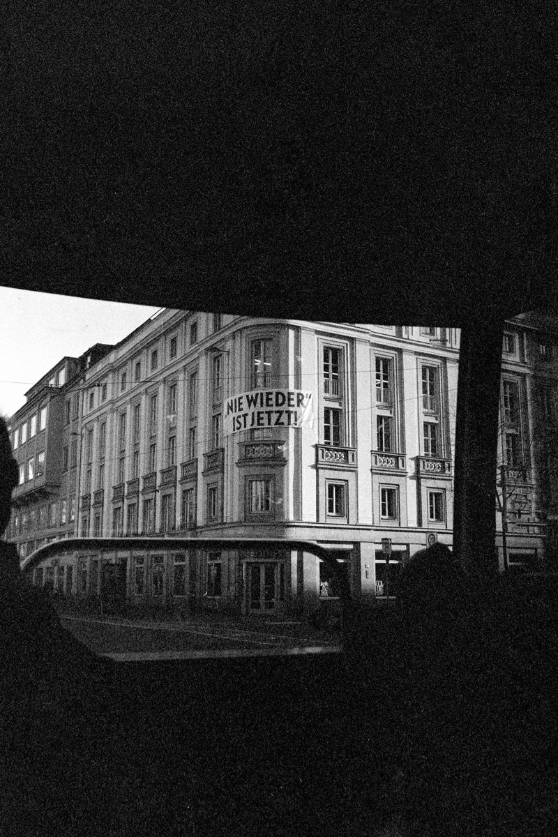 Michèl Passin. Black and white high contrast shot of a building that has been taken through a bus.