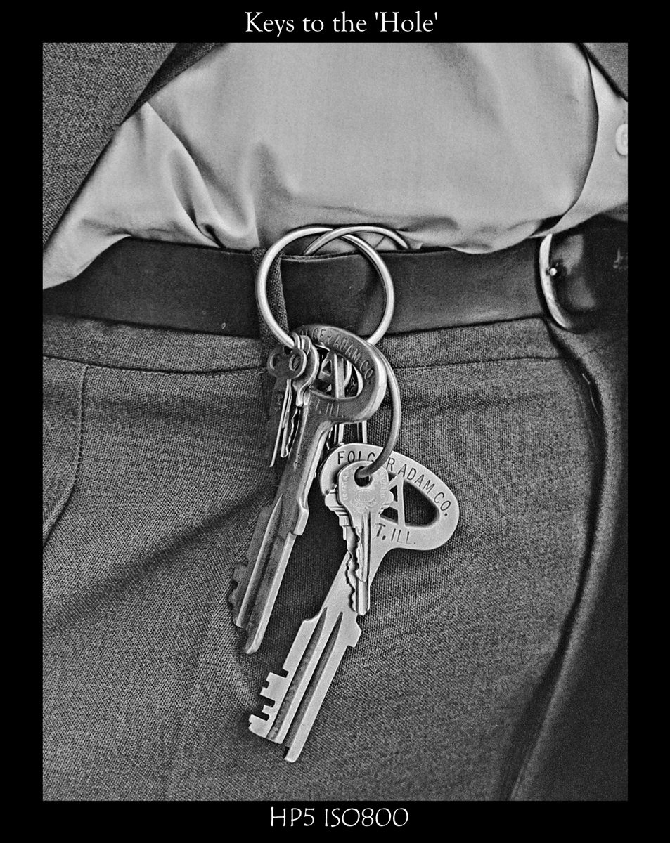 Crombie McNeill. Black and white shot of keys hanging off a mans belt.