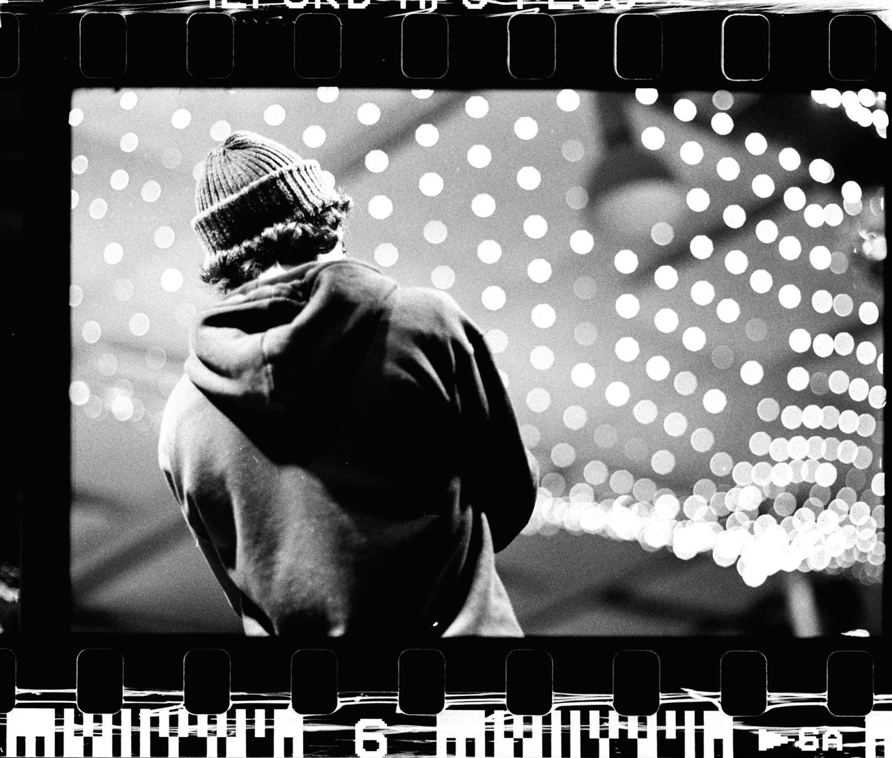 Álvaro Alberto. Black and white film negative with a man stood with his back to the camera.