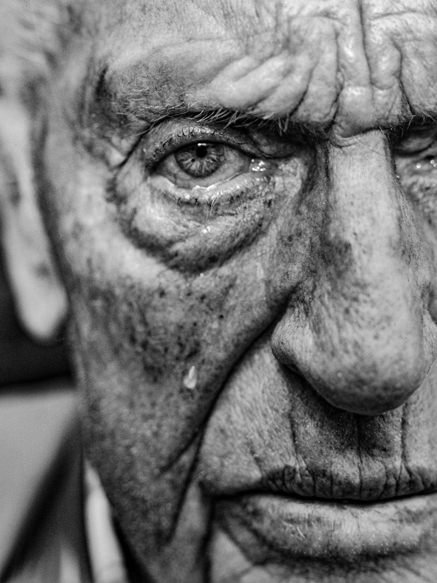 In Focus Jakob Stolz. Black and white portrait of an old man with a tear running down his face.