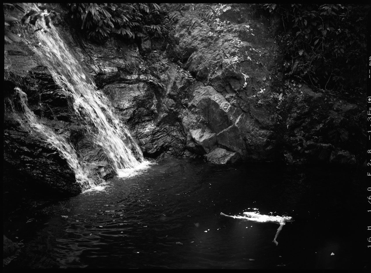 Clarissa Sofia. Black and white image of a naked woman swimming.