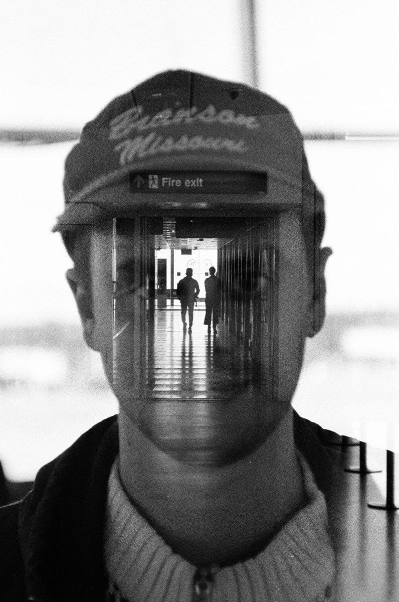 Euan Grimley. Black and white double exposure portrait with a corridor down the middle.