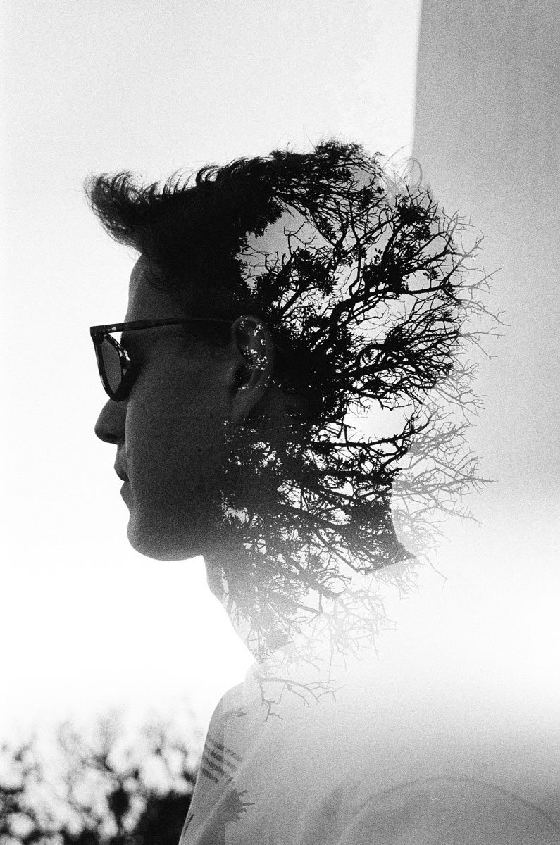 Euan Grimley. Black and white double exposure portrait with branches for hair