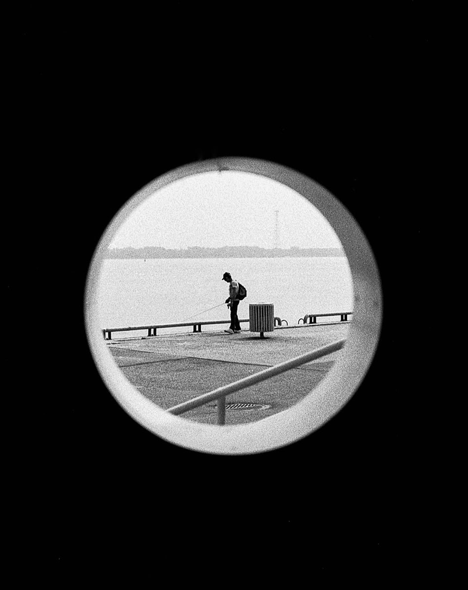 Friday Favourites #bestof2024. Black and white shot looking through a tunnel to a person stood in the middle by the sea.