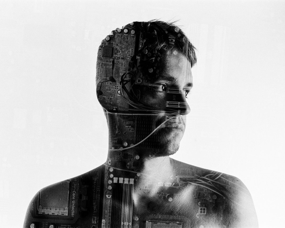 Ben Felton. Black and white double exposure of a man's portrait with an inside of a computer in his face and body.