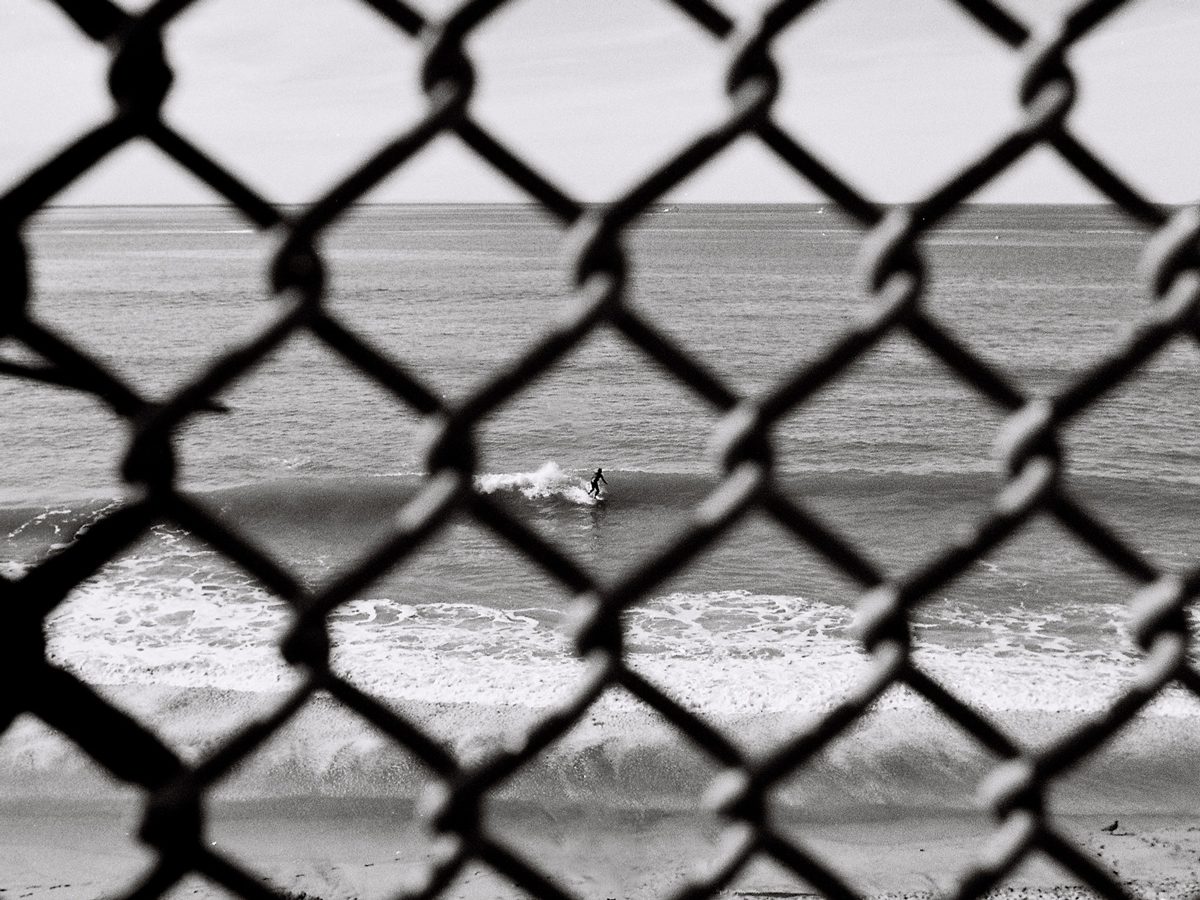 Friday Favourites #themefree. Black and white image of a fence that looks onto the sea and beach.