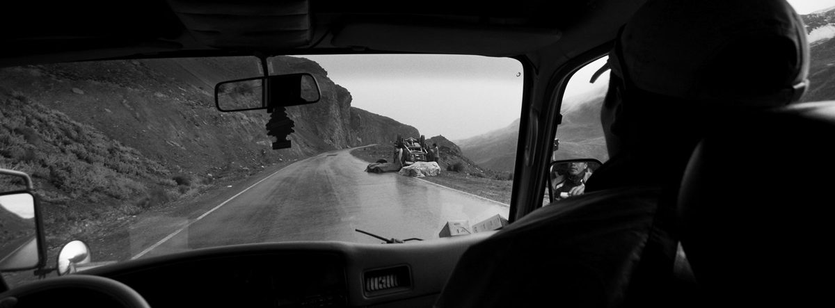 Black and white shot of a person driving inside the car