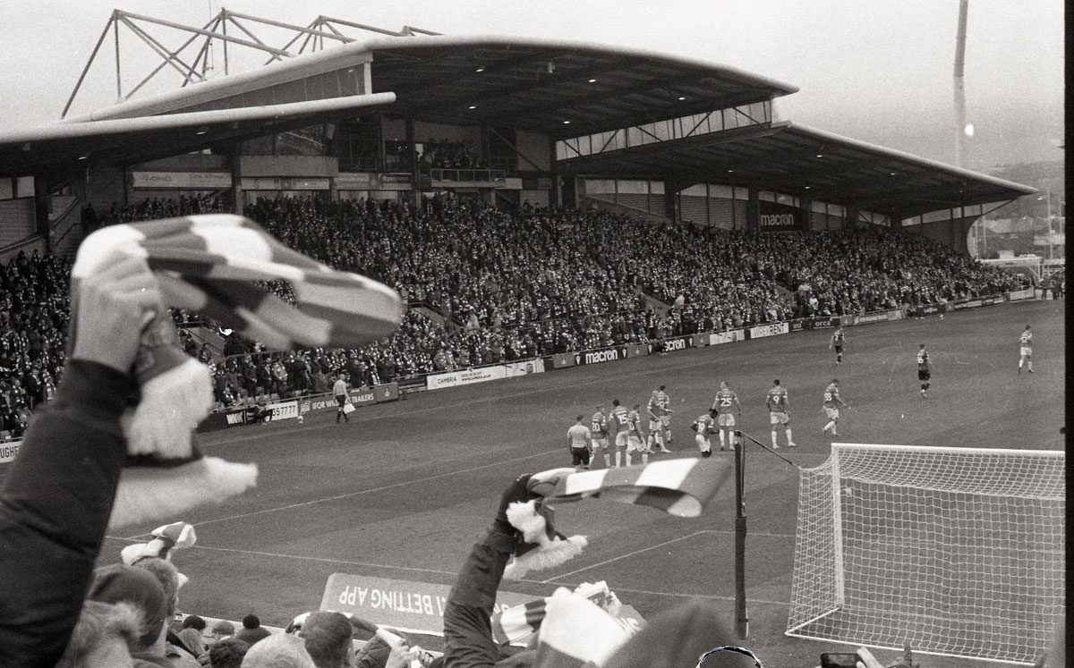 Behind The Film - Kieran Collings. Sepia image of a football pitch.