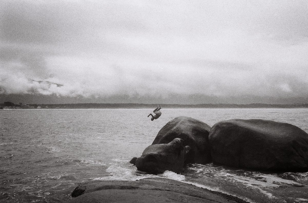 Black and white shot a man jumping into the sea