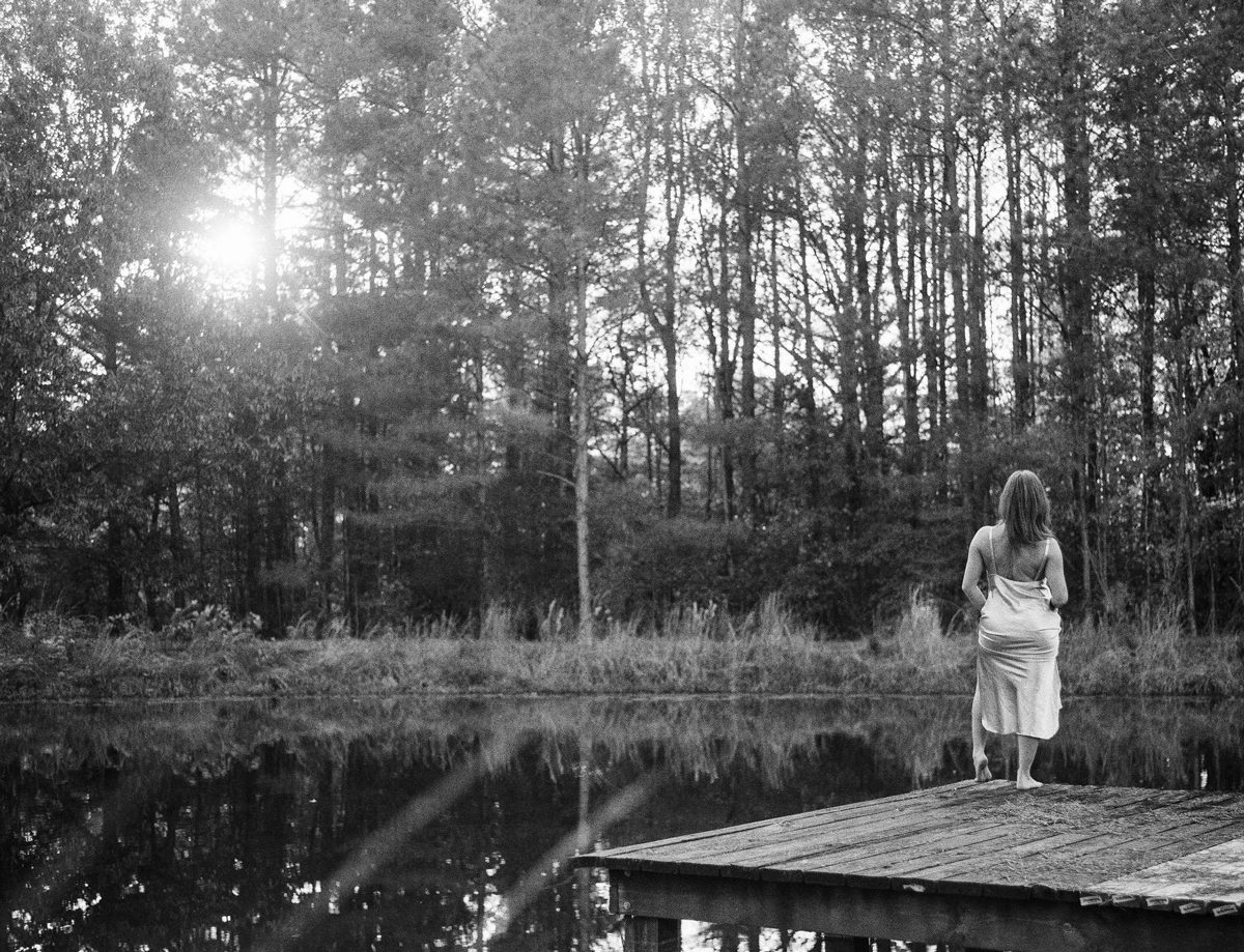 Friday Favourites #febondp400. Black and white shot of woman stood on a pier by pond.