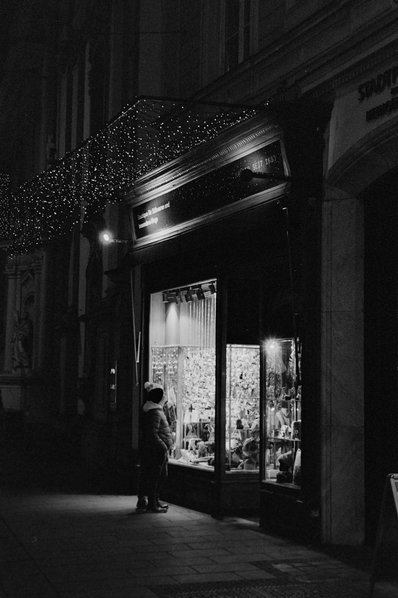 Friday Favourites #febonxp2. Black and white night time shot of a person stood outside a shop.